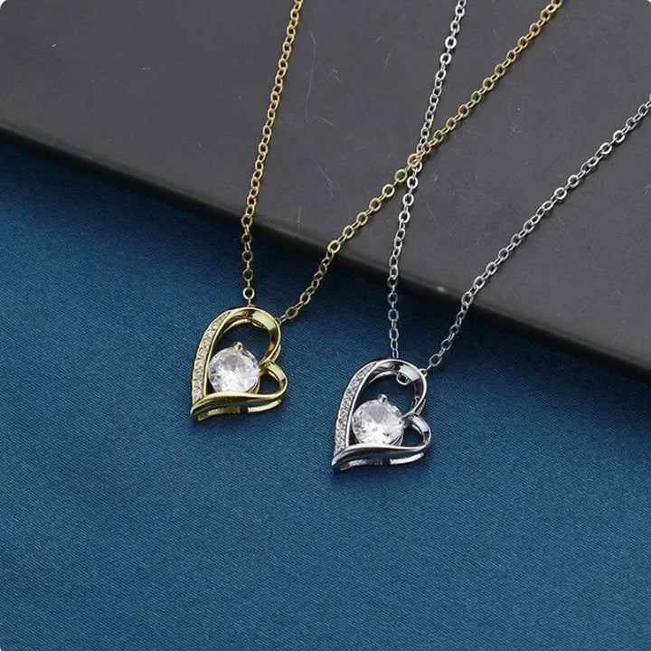 Two heart-shaped pendants on gold and silver chains against a blue background