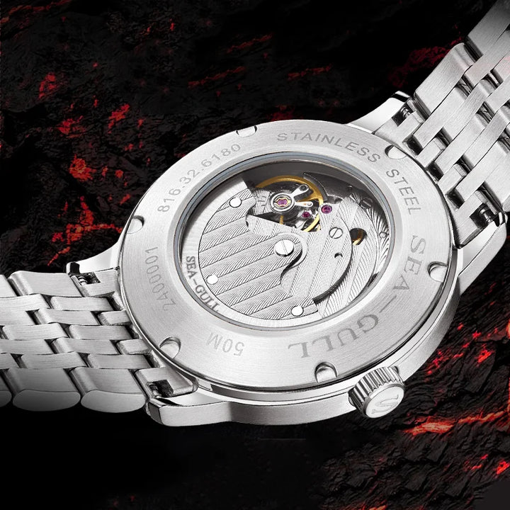 Close-up of a silver watch with visible brand name on a dark background