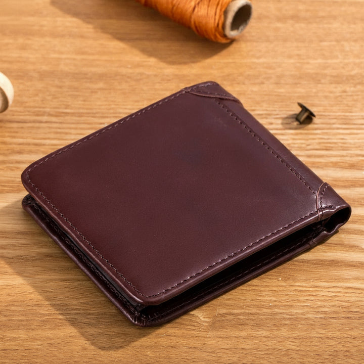 Brown leather wallet on a wooden surface with visible stitching